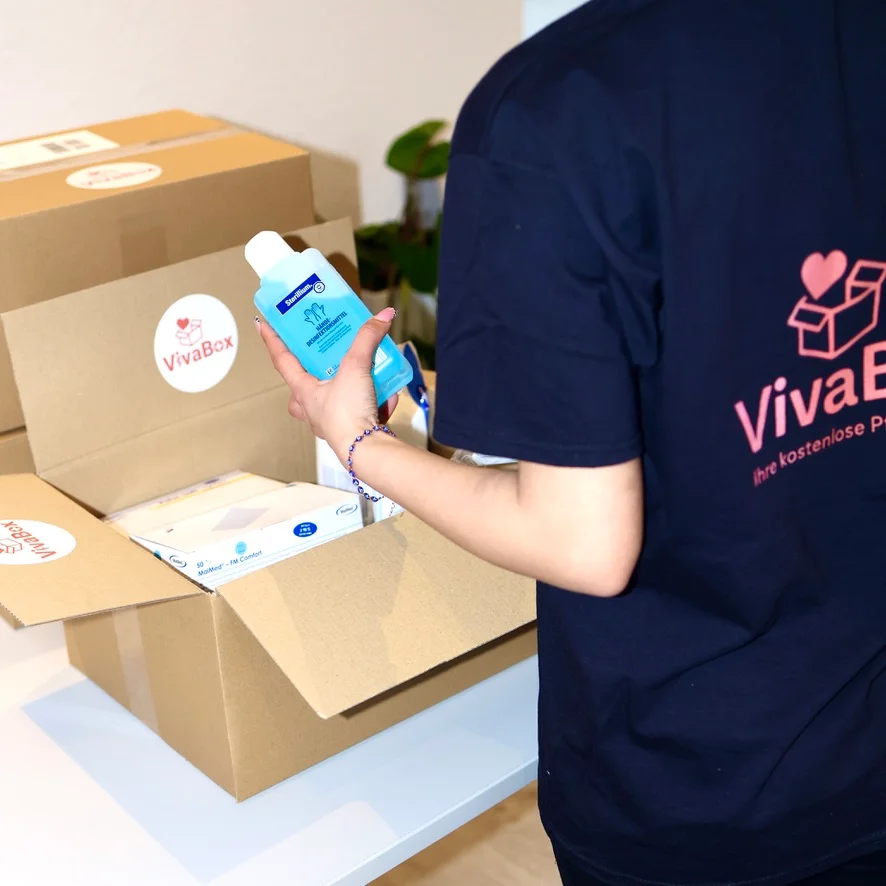 Eine VivaBox-Pflegebox wird mit Pflegehilfsmitteln gepackt